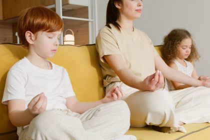 Family practicing meditation together on a couch, promoting mindfulness and relaxation.